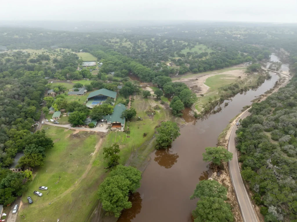 Rescue teams in boats search flood debris near Camp Mystic in Kerrville, Texas